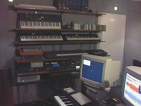 Die Klangwand. Keyboards übereinander auf Regalbrettern, darunter die Rackgeräte.